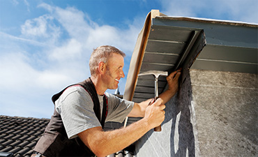 Man with hammer installing siding